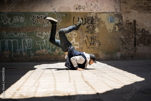 Young man breakdancing outdoors photo