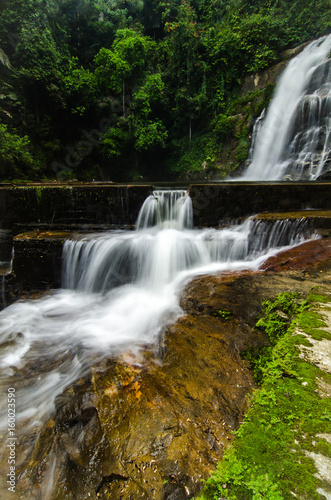 beautiful in nature  amazing cascading tropical waterfall. wet and mossy rock  surrounded by green rain forest