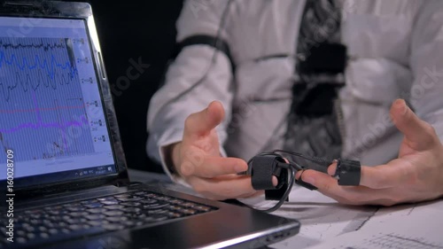 Trembling hands connected to polygraph sensors. photo