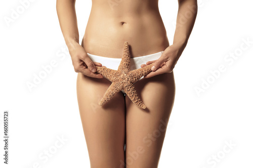 Beautiful young woman in bikini and with starfish on white background, closeup
