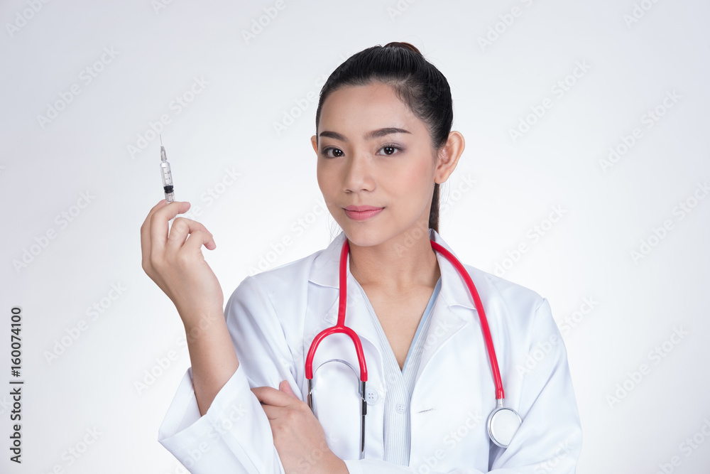 Confident smiling female doctor with a syringe in hand. Portrait of a young medical staff ready to make injection. physician or practitioner on white background Confident smiling female doctor with a syringe in hand. Portrait of a young medical staff ready to make injection. physician or practitioner on white background