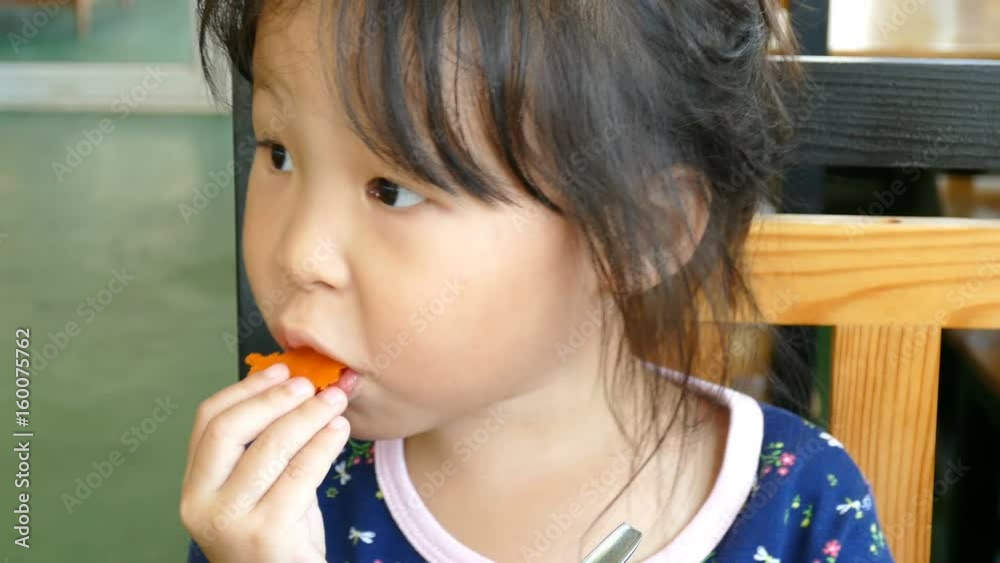 Little asian girl eating carrot Little asian girl eating carrot