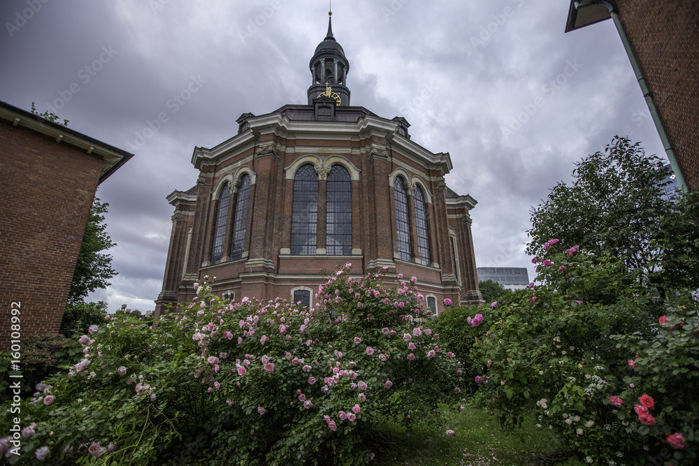 Kirchgarten mit blühenden Rosen vor einer Kirche in Hamburg