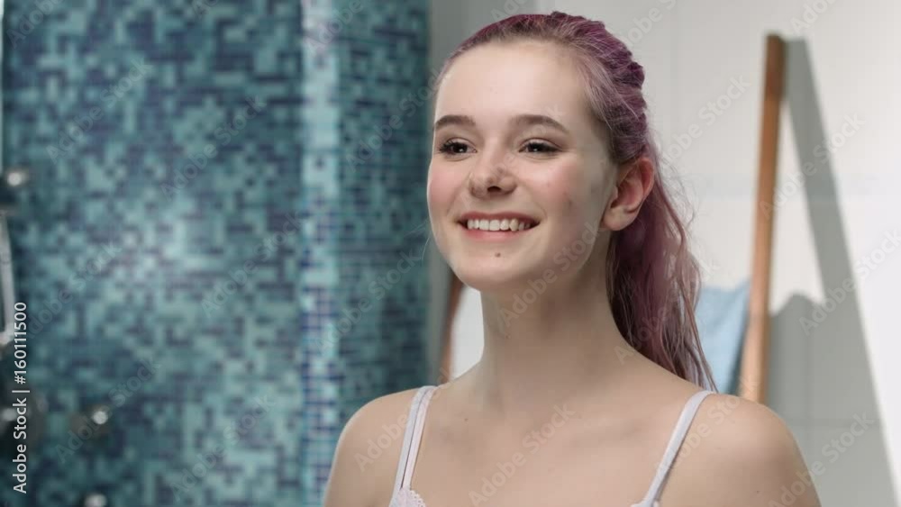 Young girl in puberty examining her armpits with a happy look Stock ビデオ