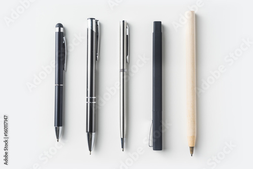 Top view of collection of pens on white background desk for mockup