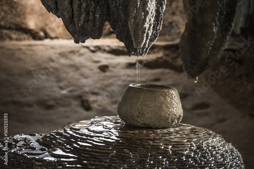 Pot filled with water from stalactites in a meditation cave in Wat Tham Sua, Krabi, Thailand photo