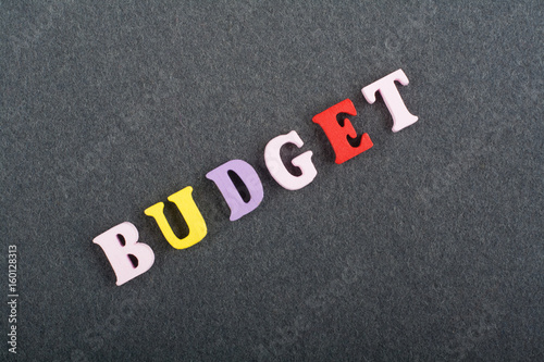 BUDGET word on black board background composed from colorful abc alphabet block wooden letters, copy space for ad text. Learning english concept.