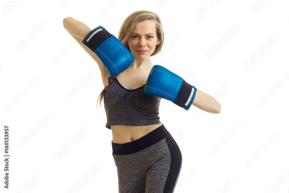 beautiful blonde stands in the Studio in boxing gloves and posing for the camera beautiful blonde stands in the Studio in boxing gloves and posing for the camera