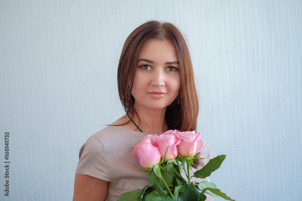 Beautiful young woman with a bouquet of roses