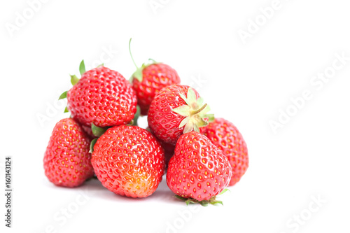 Fresh ripe strawberries on white. Red fresh berries, green leaves close-up. Shallow depth of field photography