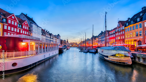 Nyhavn with its picturesque harbor with old sailing ships and colorful facades of old houses in Copenhagen, Denmark