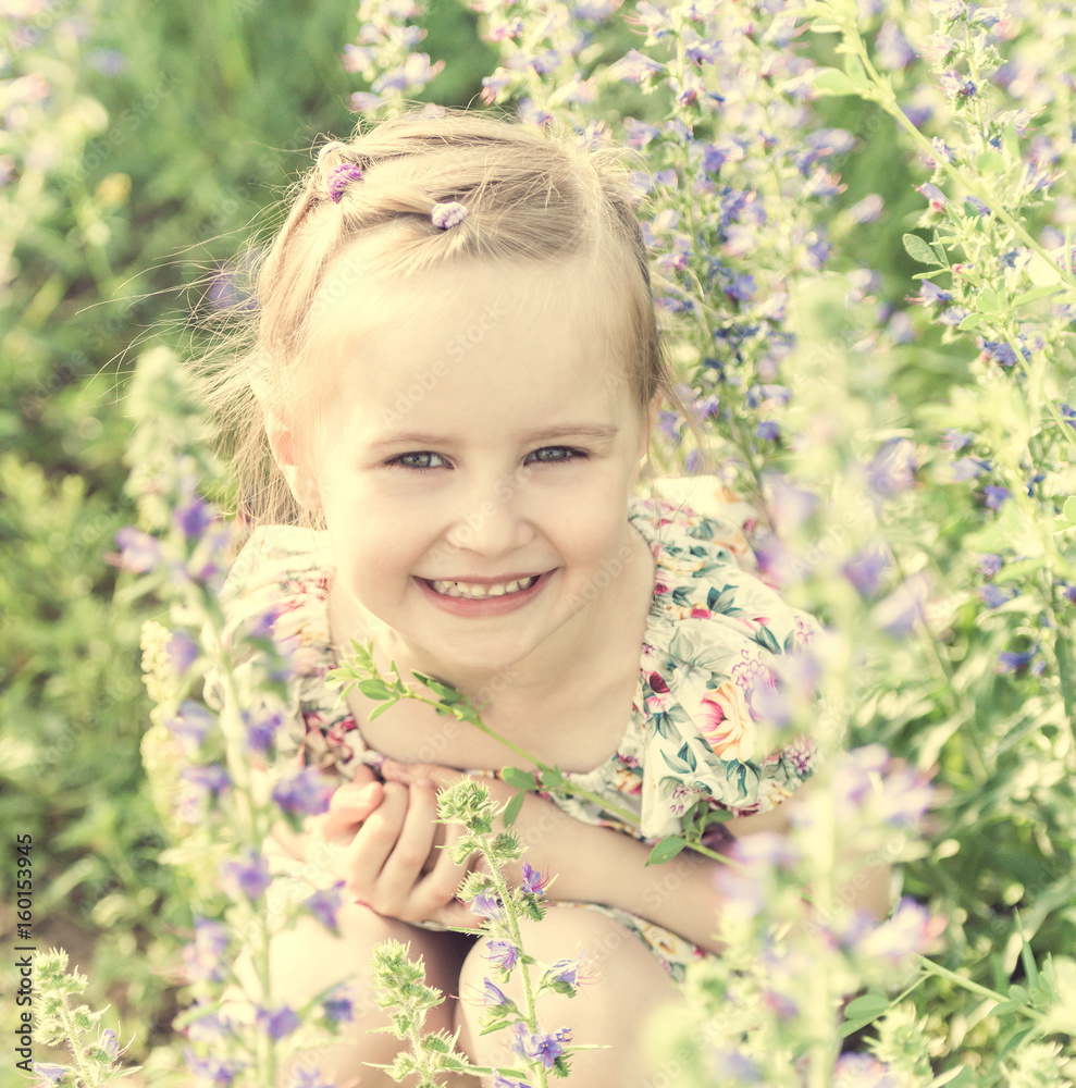 girl sitting in field full of small flowers girl sitting in field full of small flowers