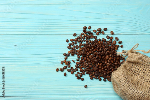 coffee beans in sackcloth on blue wooden background. With copy space. Top view.