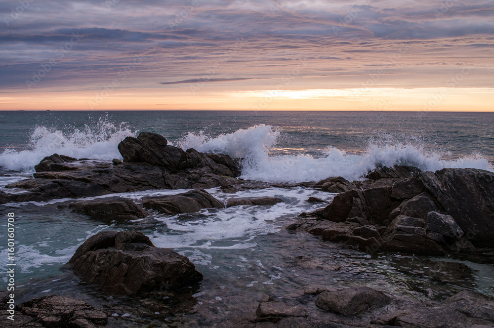 Sunset with sandy beach and splashing wave - Lofoten, Norway.