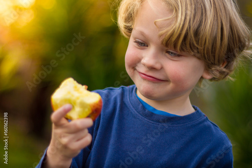 cute 5 year old child eating an apple