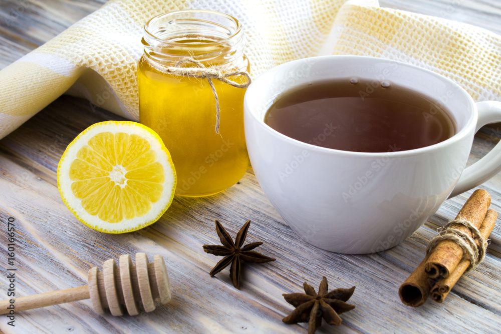 Tea, honey, cinnamon and lemon on the wooden background Tea, honey, cinnamon and lemon on the wooden background