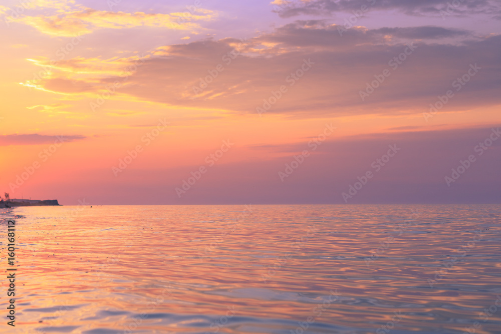 Radiance at sunset by the sea on the coast with warm color overflows and a beautiful sky