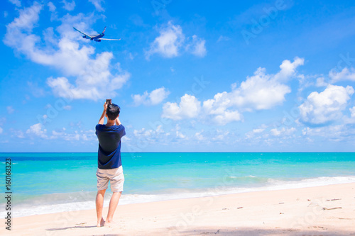mat waking on the beach and shoot photo of air plan during his summer at Phuket Thailand © nutraveller