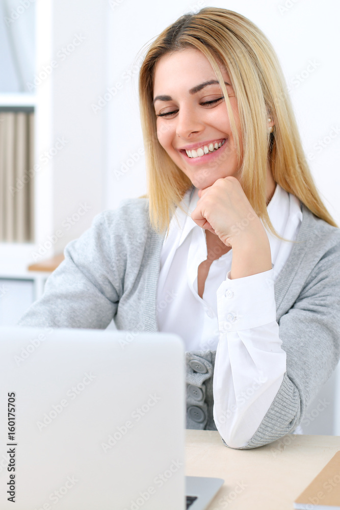 Young business woman or student girl sitting at office workplace with laptop computer. Home business concept Young business woman or student girl sitting at office workplace with laptop computer. Home business concept