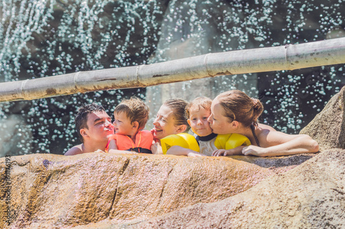 Happy adults and children in a water park photo