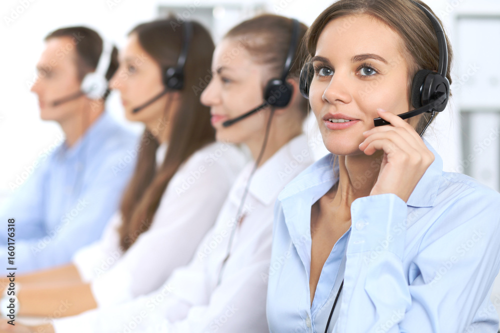 Call center operator in headset while consulting client. Telemarketing or phone sales. Customer service and business concept Call center operator in headset while consulting client. Telemarketing or phone sales. Customer service and business concept