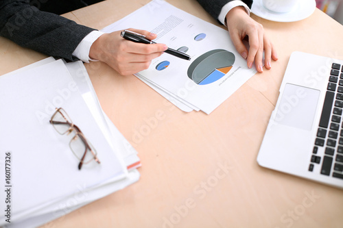 Business woman sitting at the table and examines the financial results photo