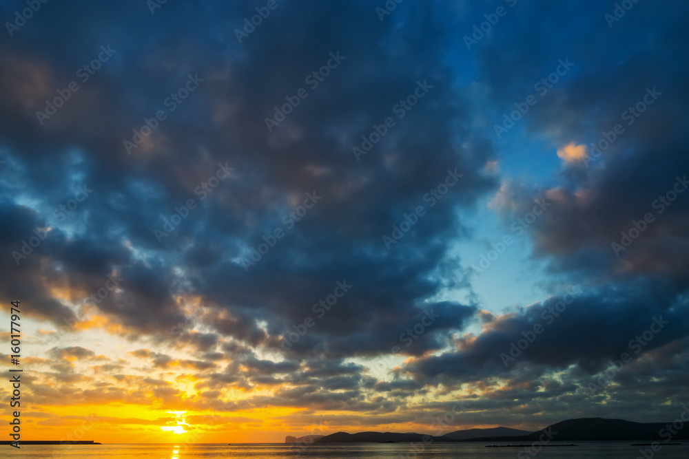 Obraz premium Dark clouds over the sea at sunset