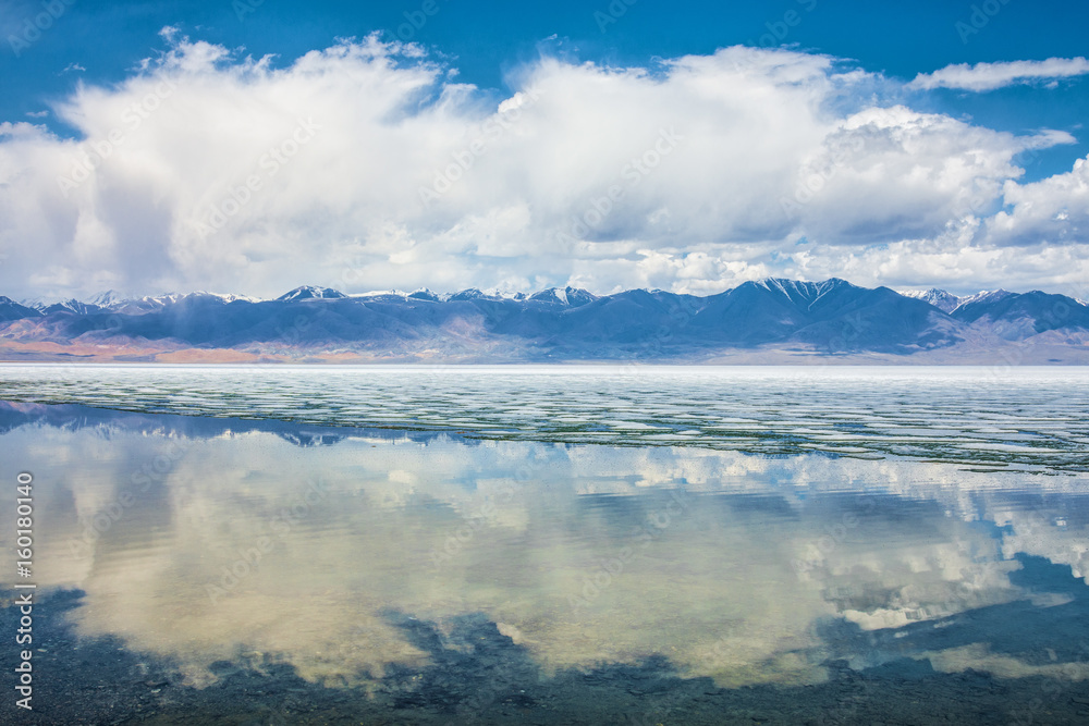 panoramic view of fluffy white clouds reflecting in watery surface of lake
