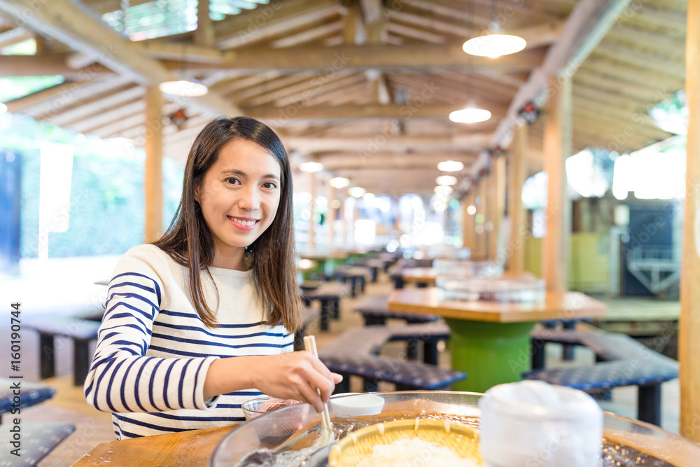 Young Woman having noodles in japanese restaurant
