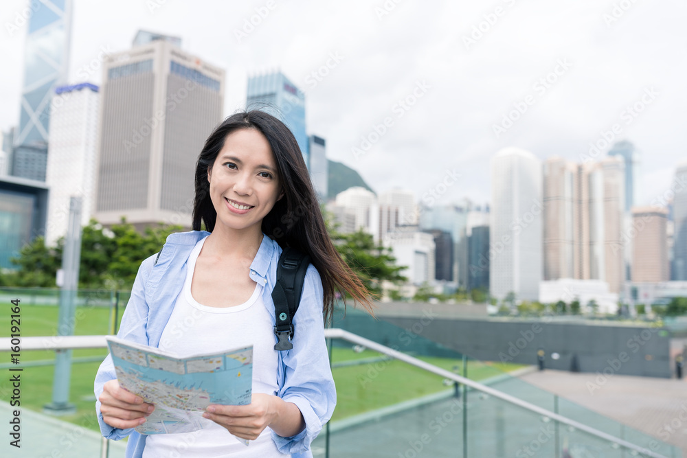 Woman use of city map in Hong Kong cityscape