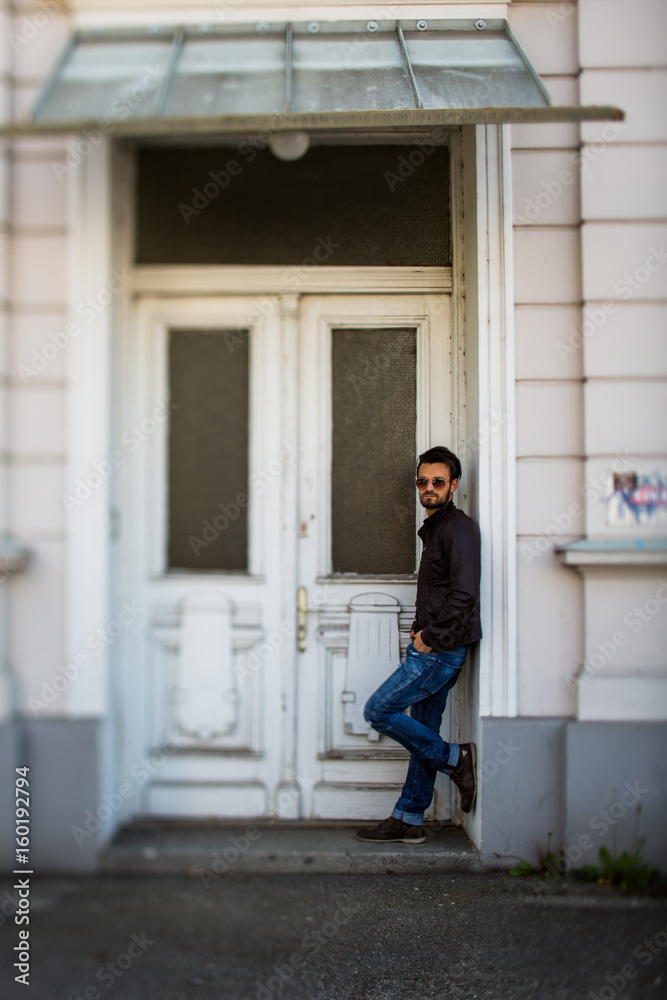 Cooler Mann in Jeans an alter Eingangstür