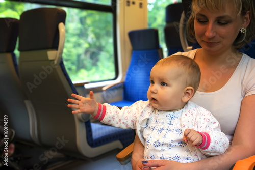 Little cute baby with blue eyes, traveling in a train