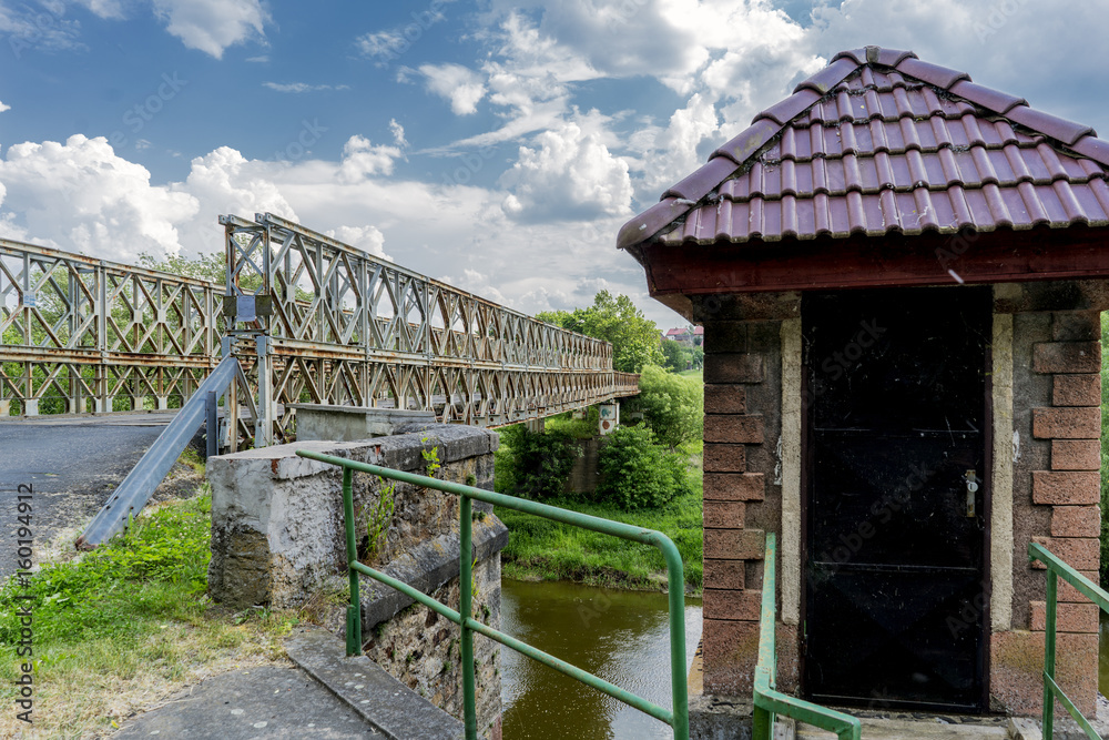 Fototapeta premium Old metal military bridge on the entrance road to the village of Kacov, Czech Republic
