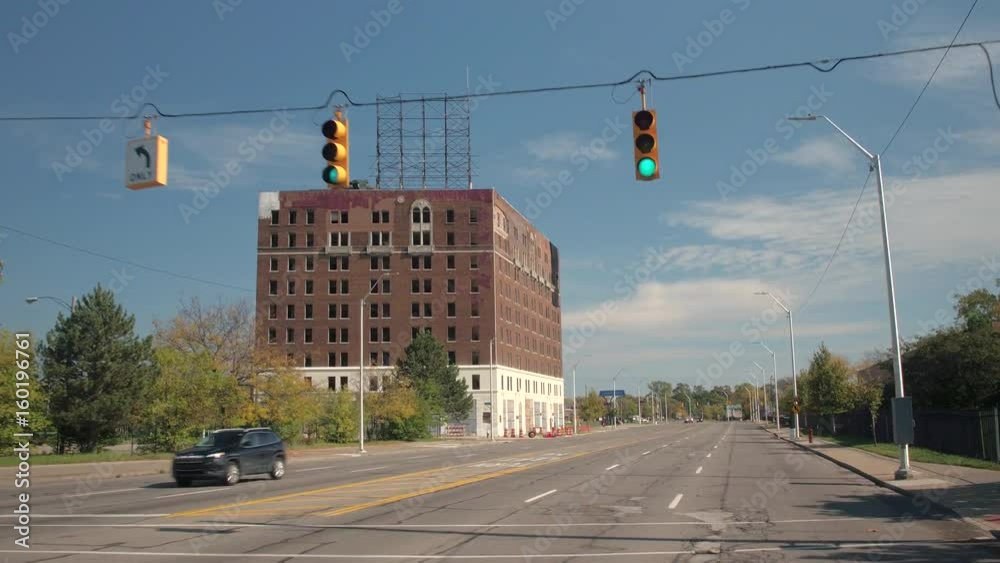 CLOSE UP: Driving along the street towards red brick-built derelict ...