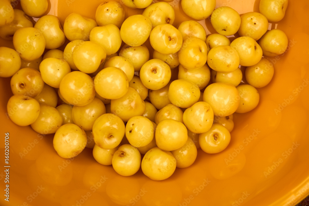 Group of yellow cherries in a yellow bowl Group of yellow cherries in a yellow bowl