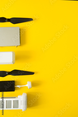 Top view of drone components, included propellers, video link, digital transmitter and screwdriver  on a yellow background photo