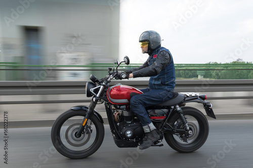Man  riding fast red motorcycle on the bridge © irena iris szewczyk