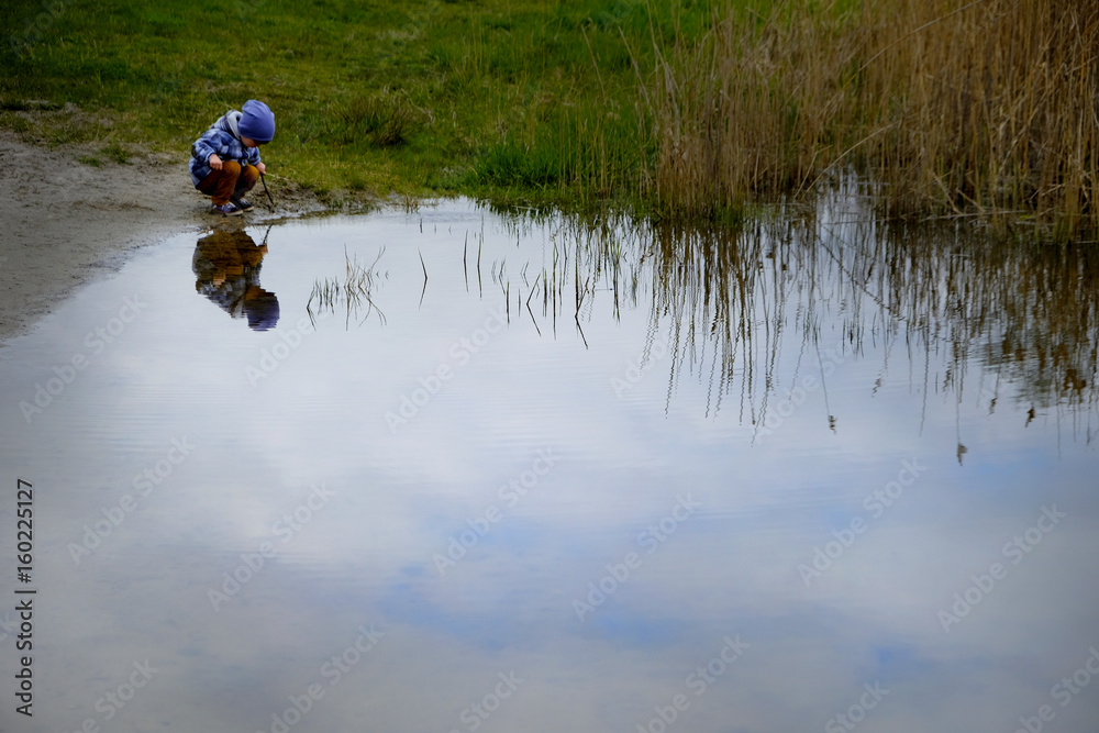 Little boy at the lake looking into a distance. Little boy at the lake looking into a distance.