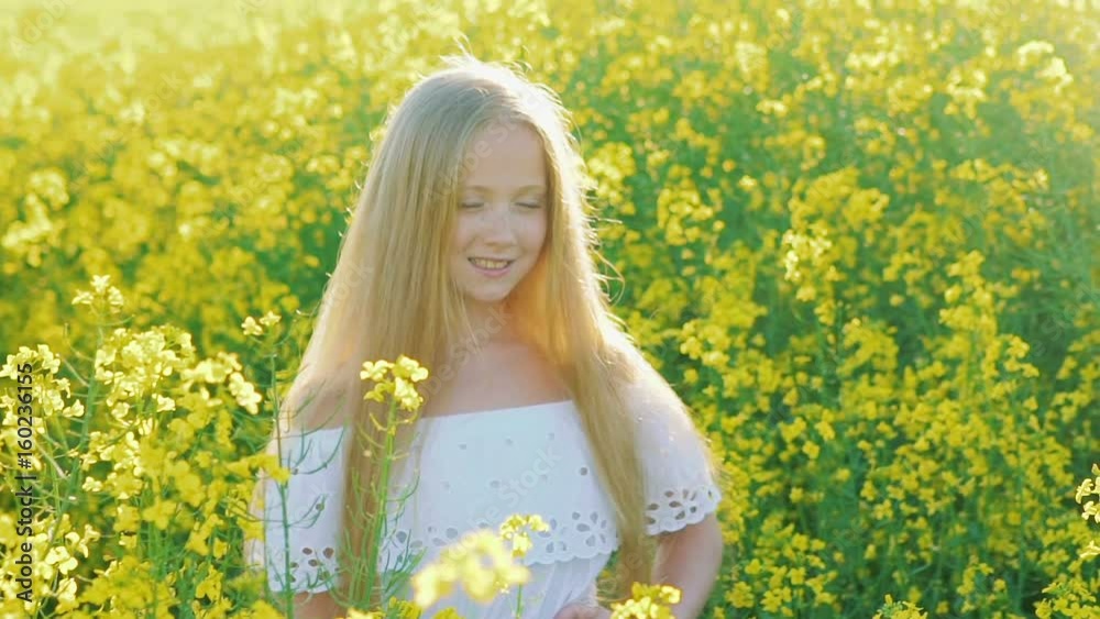 Amazing blonde posing with smile in the rape field Amazing blonde posing with smile in the rape field