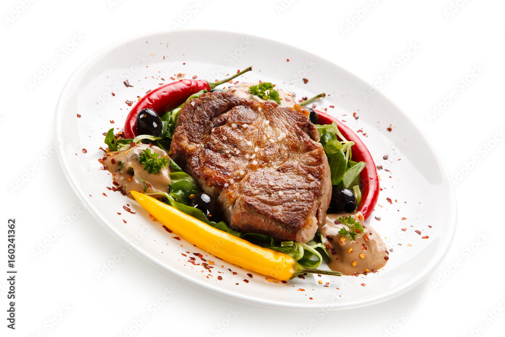 Grilled steak with vegetables on white background Grilled steak with vegetables on white background