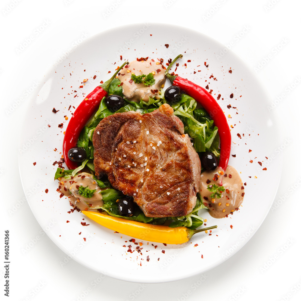 Grilled steak with vegetables on white background Grilled steak with vegetables on white background