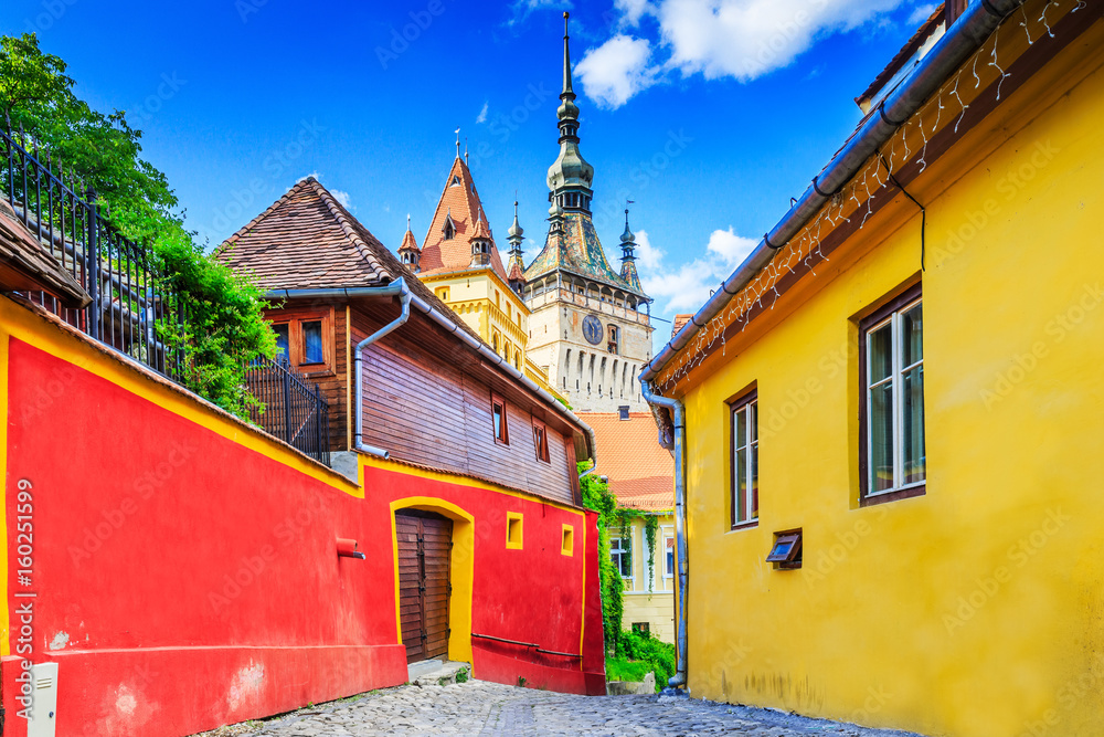 Sighisoara, Romania. Medieval street with Clock Tower in Transylvania.