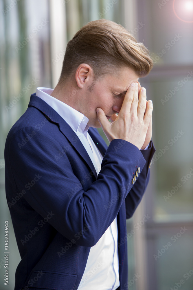 businessman standing outside and having a headache businessman standing outside and having a headache