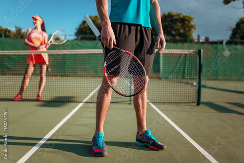 Man and woman plays tennis on open air