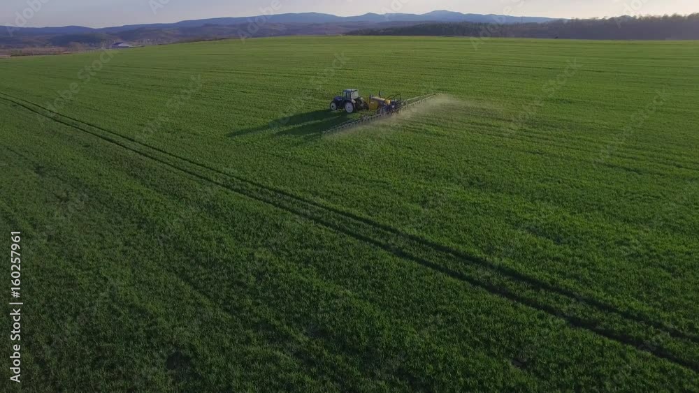 Drone flying over the spraying tractor Drone flying over the spraying tractor