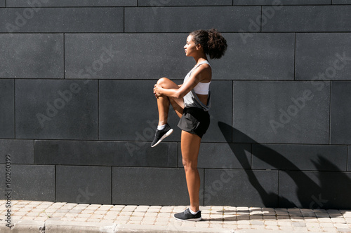 Side view of female athlete stretching leg © Artem Varnitsin