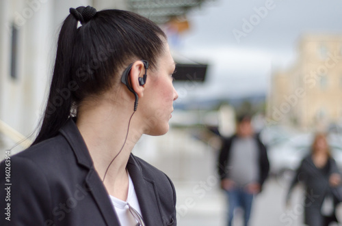 woman bodyguard with headset look at back photo