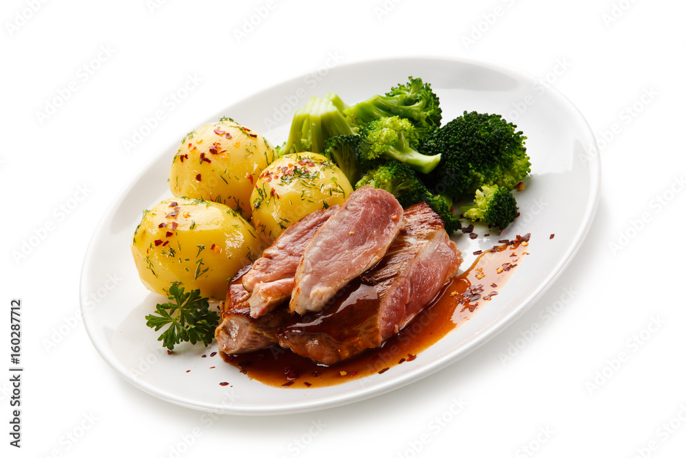 Grilled beefsteak with broccoli and carrot on white background Grilled beefsteak with broccoli and carrot on white background