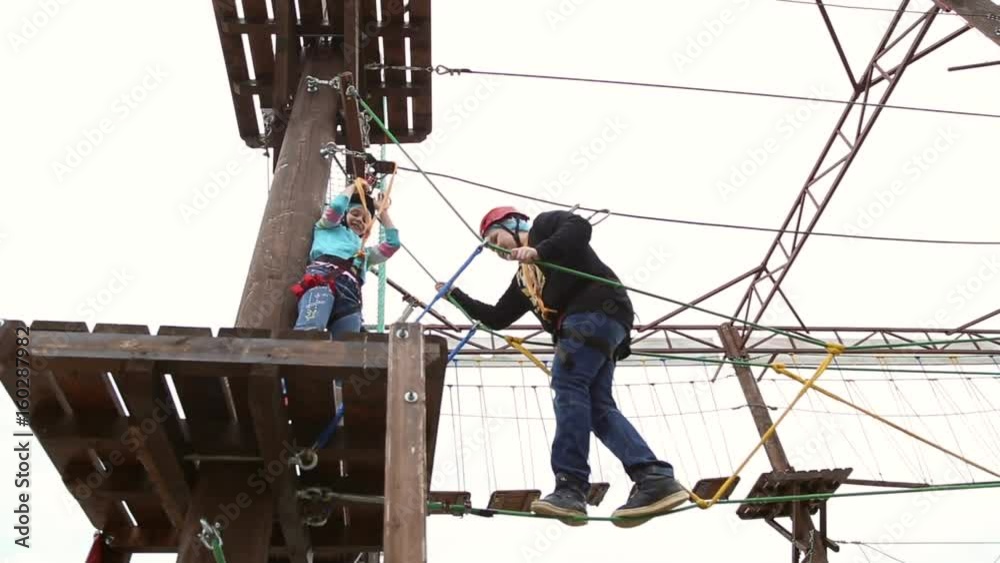 Boy in climbing equipment, he overcomes a challenging obstacle course, entertainment extreme attraction Boy in climbing equipment, he overcomes a challenging obstacle course, entertainment extreme attraction