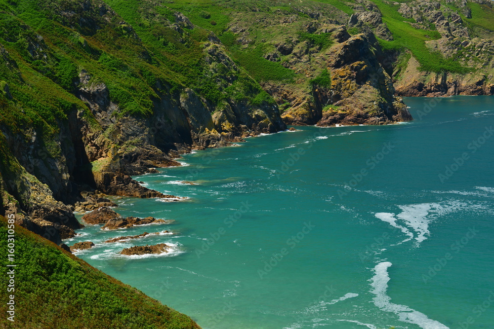 Plemont Bay, Jersey, U.K. Telephoto image of an idyllic bay in the Summer at high tide. Plemont Bay, Jersey, U.K. Telephoto image of an idyllic bay in the Summer at high tide.